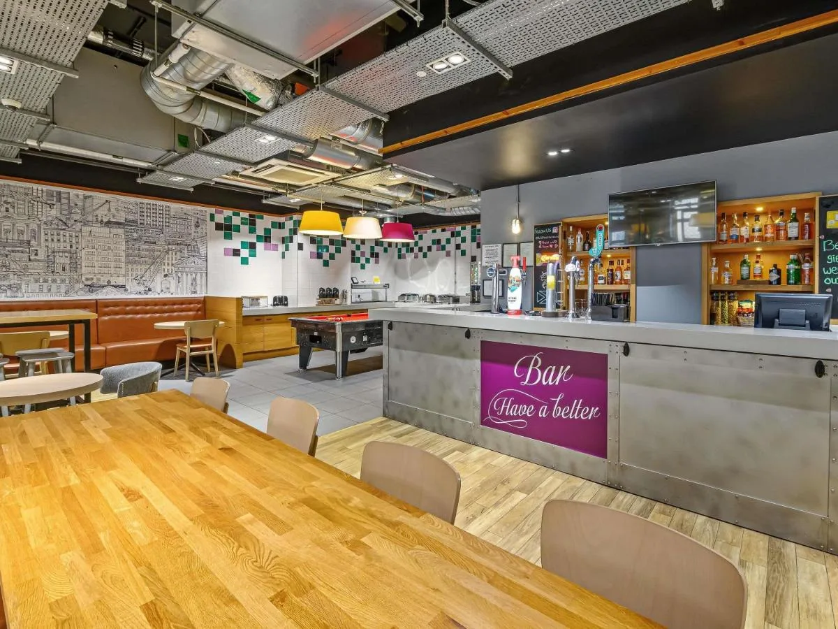 a dining room with a table and a bar at ibis Styles Glasgow Centre George Square in Glasgow