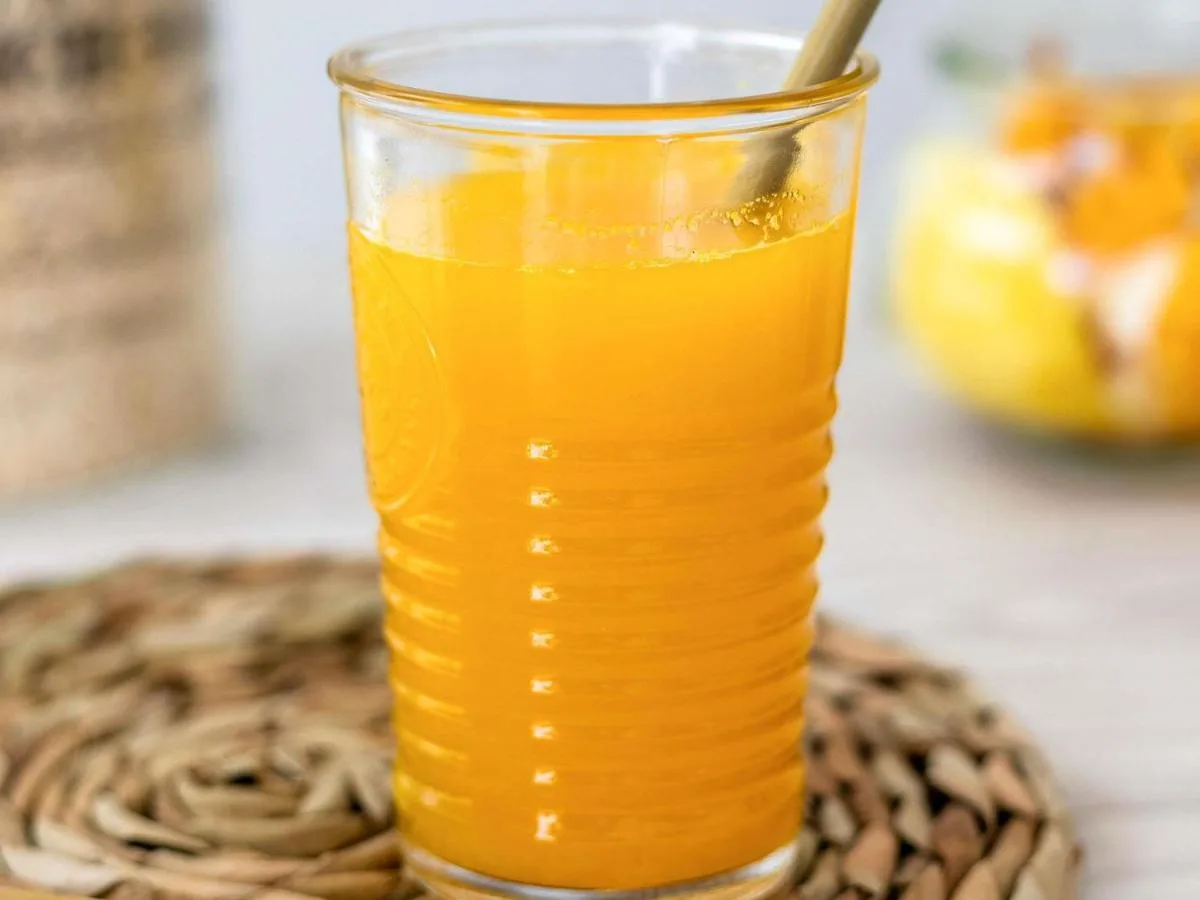 a glass of orange juice with a spoon in it at ibis Styles Glasgow Centre George Square in Glasgow