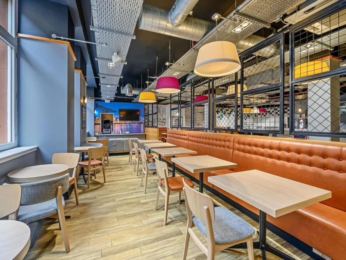 a row of tables and chairs in a restaurant at ibis Styles Glasgow Centre George Square in Glasgow